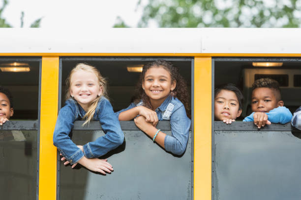 istock Elementary school children looking out window of bus 920485698