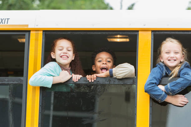 istock Elementary school children looking out window of bus 920485862