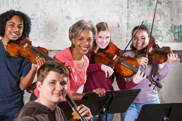 teenager geiger mit musiklehrer - practicing music violin women stock-fotos und bilder