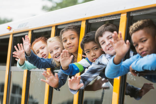 istock Elementary school children looking out window of bus 920486264