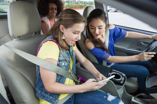 adolescentes no carro rindo, usando telefone celular - text messaging mobile phone teenagers only people - fotografias e filmes do acervo