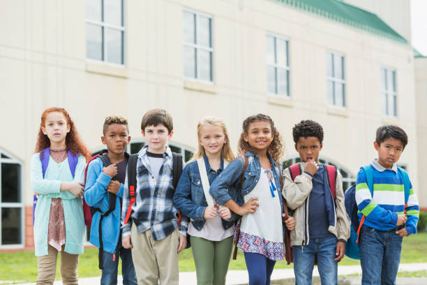 istock Multi-ethnic school children standing outside building 920488822