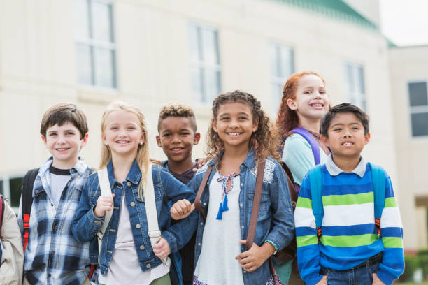 istock Multi-ethnic school children standing outside building 920488824