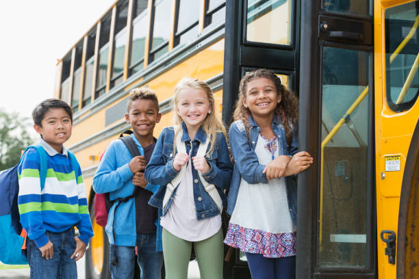istock Multi-ethnic school children standing outside bus 920489384