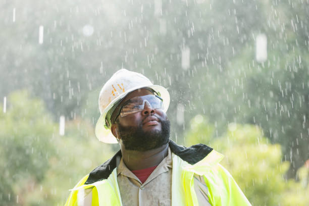 trabalhador africano-americano, em pé na chuva - shower human face men wet - fotografias e filmes do acervo