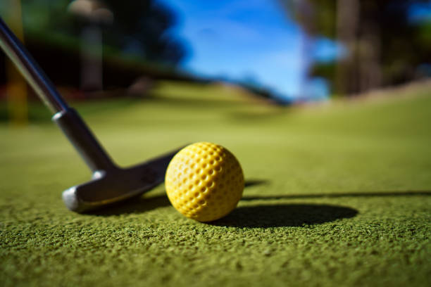 istock Mini Golf yellow ball with a bat at sunset 920496400