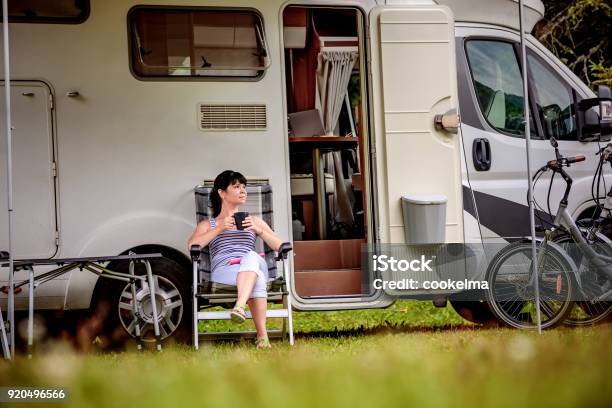 Photo libre de droit de Femme Est Debout Avec Une Tasse De Café Près De La Roulotte Rv banque d'images et plus d'images libres de droit de Camping-car