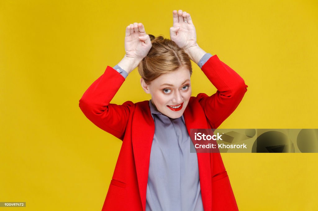 Femme d’affaires de drôle dans le costume rouge montrant lapin signe. - Photo de Excentrique libre de droits