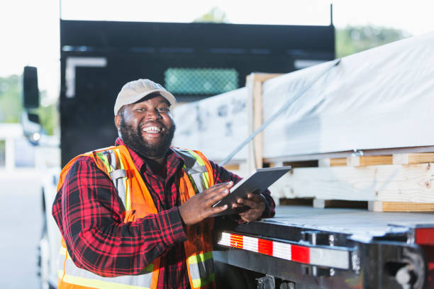 istock Worker standing by truck loaded with building material 920497520