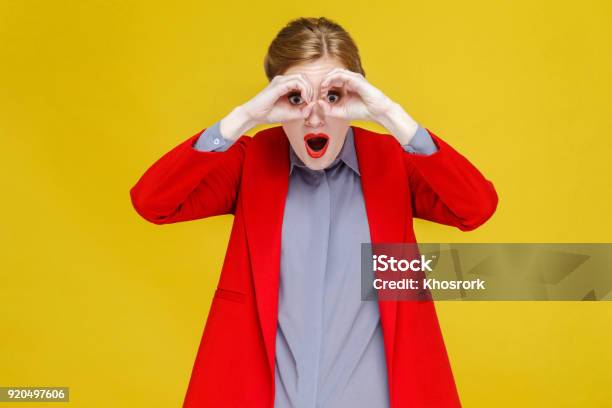 Mujer Cabeza Roja En Traje Rojo De Binoculares Lejano Foto de stock y más banco de imágenes de Binoculares