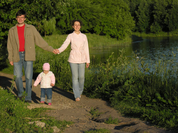 Family walking down a path at the Zoo, father carrying son on his shoulders.