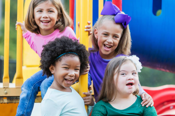 ragazze multietniche che giocano nel parco giochi - playground schoolyard playful playing foto e immagini stock