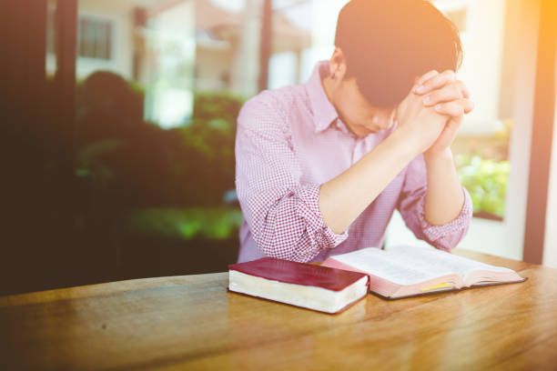 istock man praying on holy bible in the morning 920504814