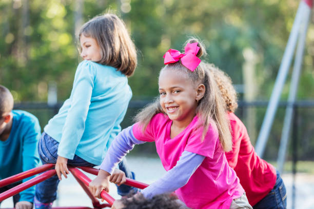 istock Little girl playing on monkey bars with friends 920511162