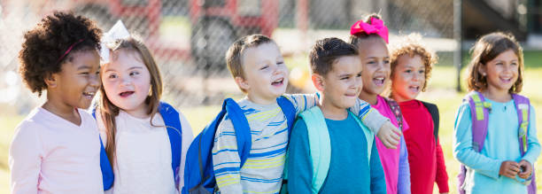 grupo multiétnico de pie en una fila de escolares - little boys preschooler back to school backpack fotografías e imágenes de stock