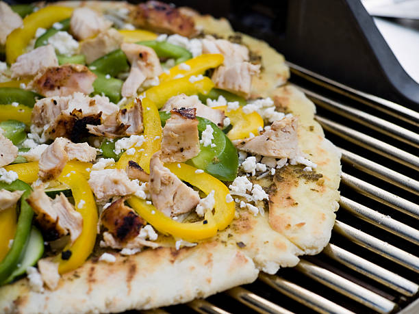 Mediterranean style gourmet barbequed pizza on a grill
