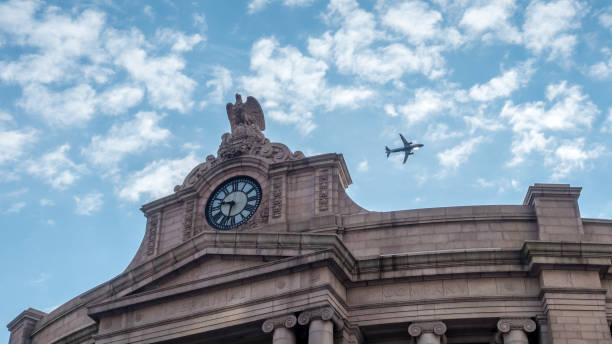 Airplane Climbing After Take Off Behind A Train Terminal Building