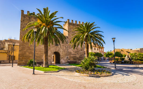 перед воротами порта-де-ксара, порта-дель-молл в историческом центре города алькудия, майорка испания - fort fortified wall castle stone стоковые фото и изображения