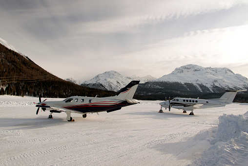 Two propeller type private jet and planes in the snow covered airport in the alps switzerland in winter