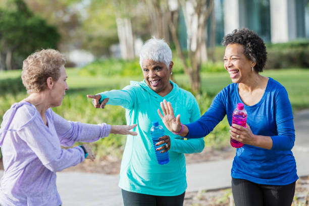 istock Three mature women in park talking, laughing playfully 920524724