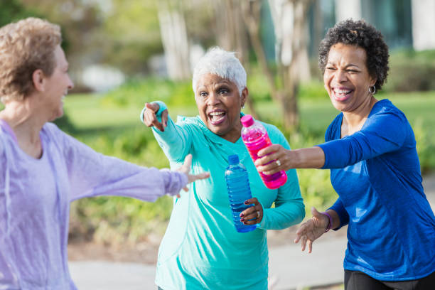 istock Three mature women in park talking, laughing playfully 920524812