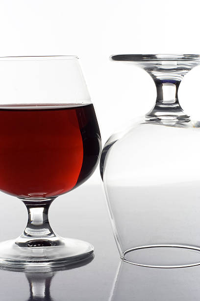 two glass on table one full another empty stock photo