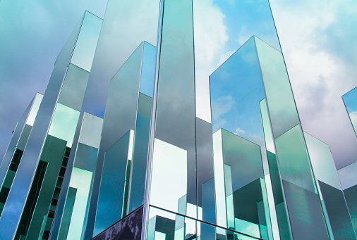 Bottom view of reflection of blue sky on building mirror. Abstract background.