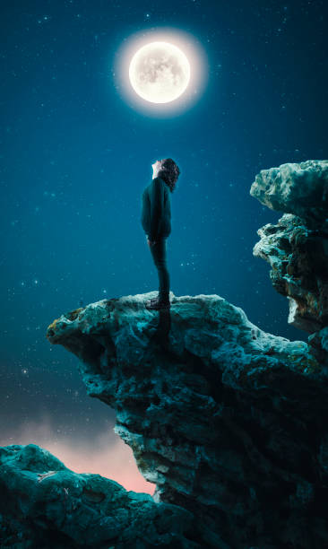 istock Woman standing on cliff and looking up to the moon. 920534462