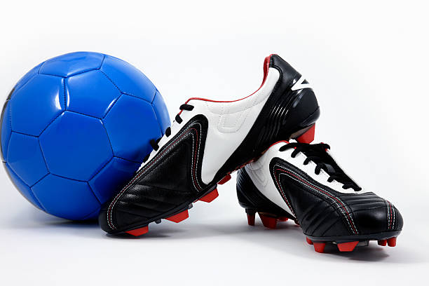 pallone da calcio e scarpe chiodate - scarpe chiodate foto e immagini stock