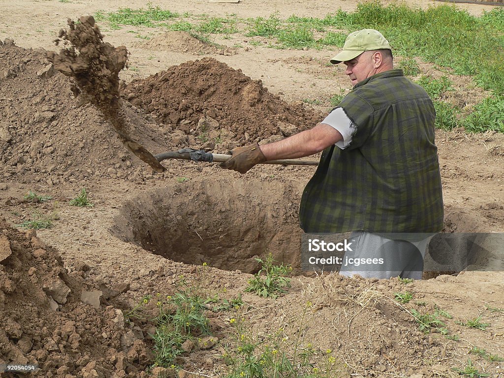 Rugged man digging deep hole with shovel  Digging Stock Photo