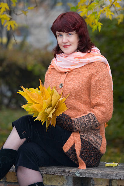istock Woman sitting with autumn leaves 92054920