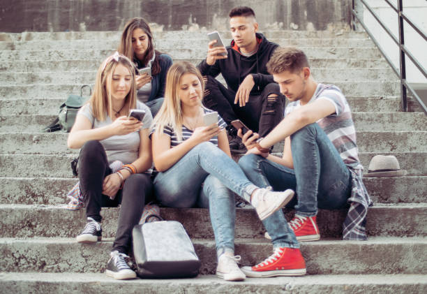 people obsessed with their smartphones - staring imagens e fotografias de stock