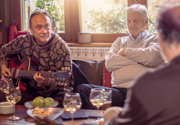 istock Middle aged man playing guitar for his friends 920554840