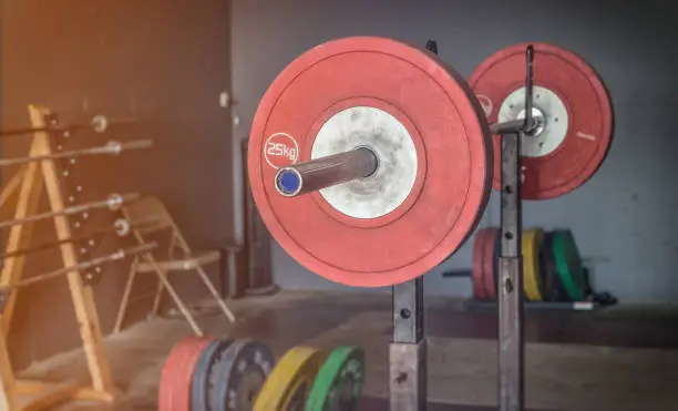 A barbell loaded with weights sits above an Olympic style platform.