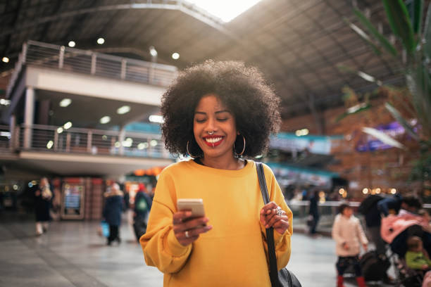 Beautiful woman using mobile in the train station.