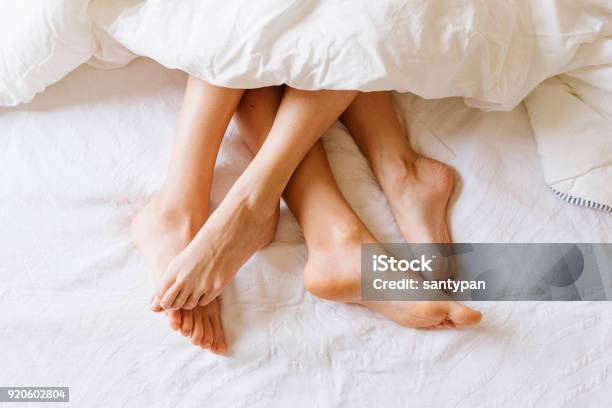 Cerca De Los Pies Femeninos Foto de stock y más banco de imágenes de Cama - Cama, Parejas, Pie - Anatomía