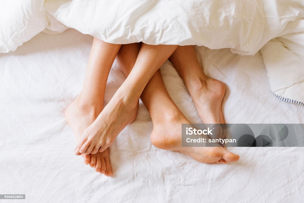 女性の足のクローズ アップ。 - ベッドのロイヤリティフリーストックフォト