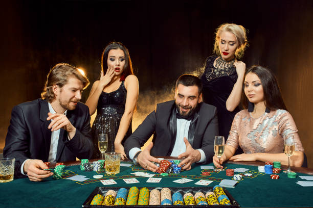 poker players sitting around a table at a casino - smiling casino human hand beautiful imagens e fotografias de stock