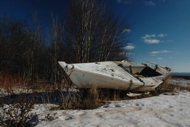 An abandoned fishing boat lies on the coast.