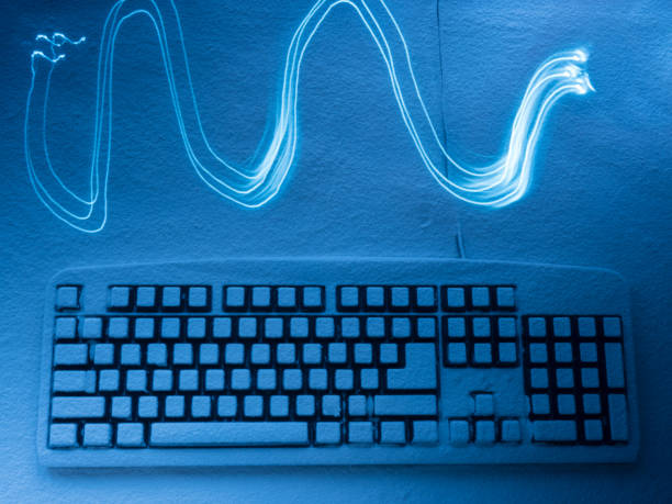 istock computer keyboard covered with snow illuminated by blue light with traces in the form of a waves from drawing by light 920619902