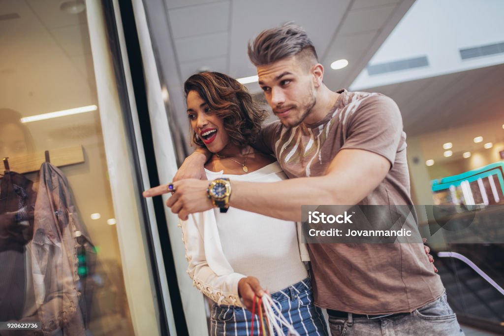 Junge glückliche Paar Blick auf ein Fenster ein Bekleidungsgeschäft in der Shopping mall - Lizenzfrei Attraktive Frau Stock-Foto