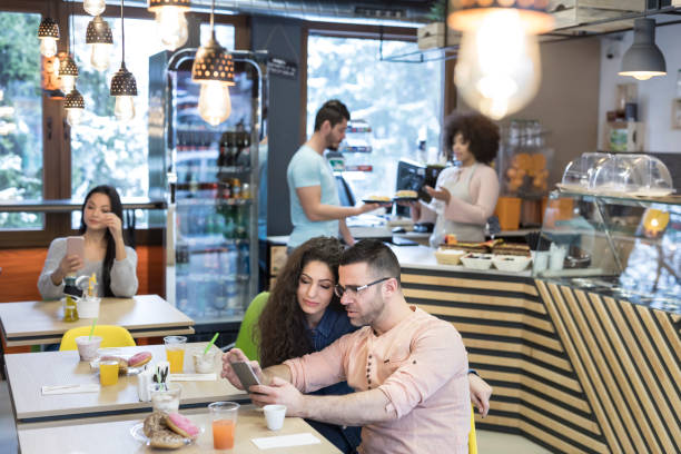 istock Couple social networking in cafeteria 920631590