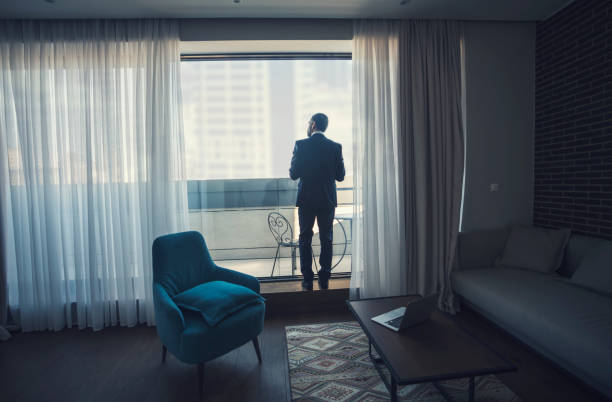 istock Businessman looking through window of hotel 920645538