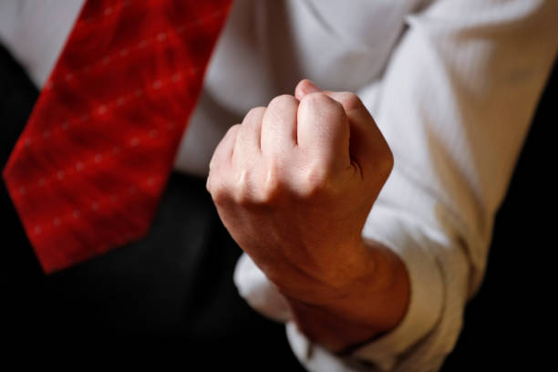Close-up photo of a businessman (politician) showing his clenched fist. Shallow depth of field - focus on the fist. Can illustrate the concept of threat, anger, stress, etc. High resolution - 50 megapixels.