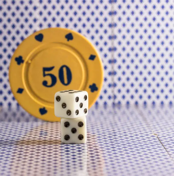 Photo of light dice on the background of poker chips