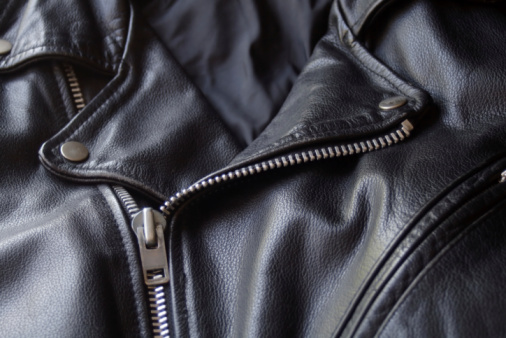 Stylish leather jacket on a hanger isolated on a white background. Clothing made of genuine leather.