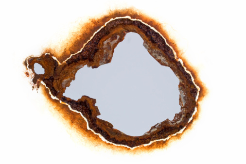 A rusty hole in a white sheet of steel.  Easily faded into most colour backgrounds.