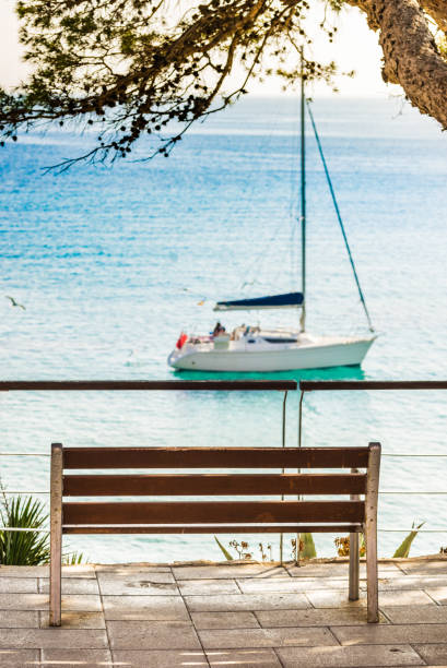istock Empty bench with sea view of sailing boat at bay 920669326