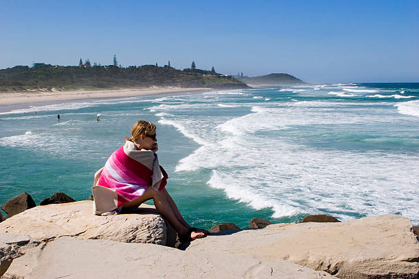 Girl watching surfers stock photo