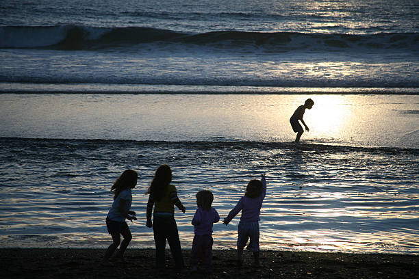 Young Children at Beach  big family sunset stock pictures, royalty-free photos & images